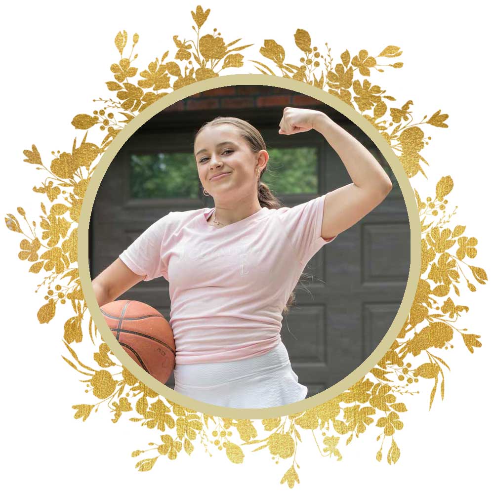 Young girl with basket ball flexing her muscles